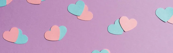 Бесшовный рисунок цветных бумажных сердец на фиолетовом фоне, панорамный снимок — стоковое фото