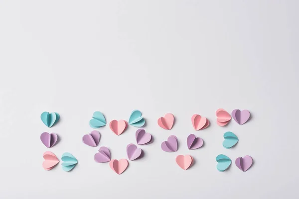 Vue du dessus de lettrage d'amour fait de coeurs en papier coloré sur fond blanc — Photo de stock
