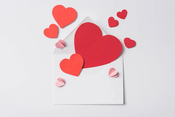 Top view of red hearts and envelope on white background — Stock Photo