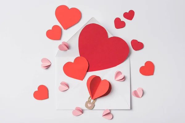 Top view of red hearts on envelope on white background — Stock Photo