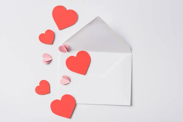 Top view of red hearts and envelope on white background — Stock Photo