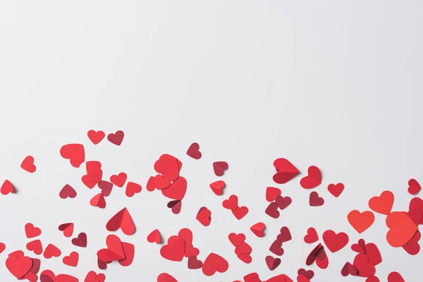 Vista superior de corações vermelhos espalhados no fundo branco — Fotografia de Stock