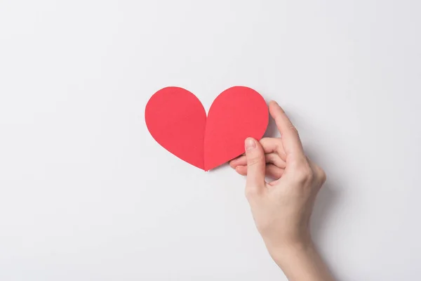 Cropped view of woman holding red heart on white background — Stock Photo