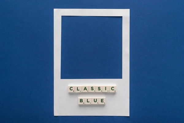 Top view of classic blue lettering on cubes on white photo frame on blue background — Stock Photo