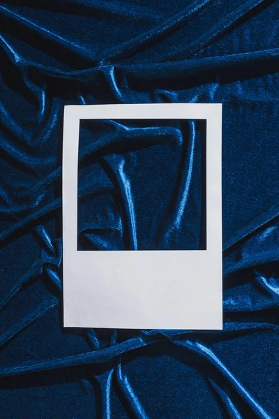 Top view of empty white photo frame on blue velour cloth — Stock Photo