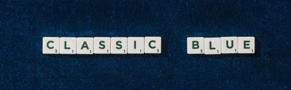 Vista superior de letras azules clásicas en cubos sobre fondo de terciopelo azul, plano panorámico - foto de stock