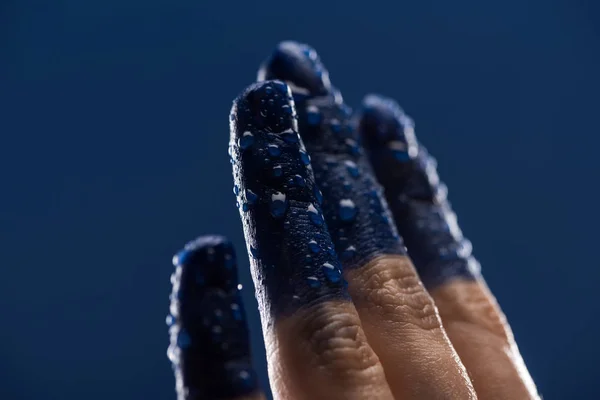 Close up view of female hand with wet painted fingers isolated on blue — Stock Photo