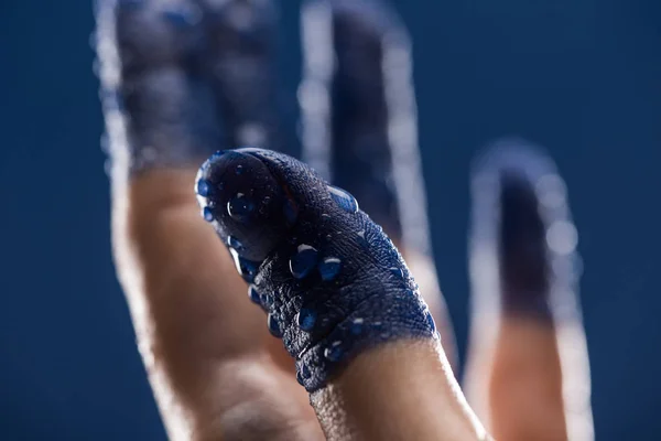 Close up view of female hand with wet painted fingers isolated on blue — Stock Photo