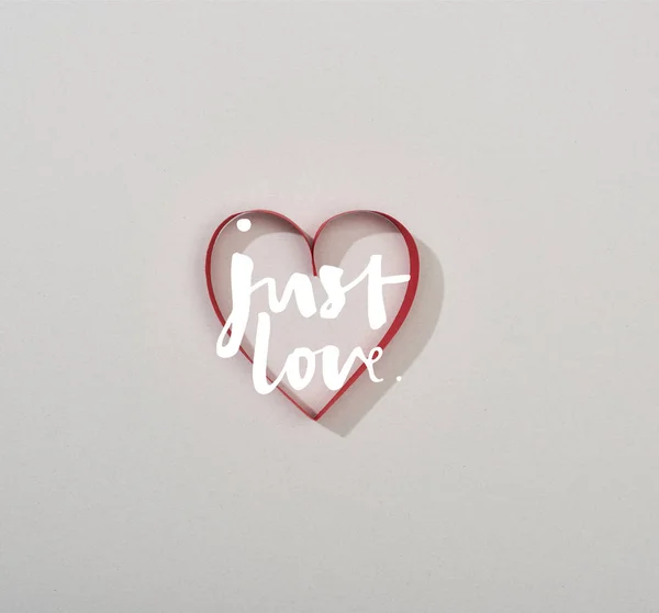 Top view of red paper heart on grey background with just love lettering — Stock Photo