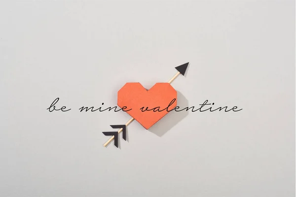 Top view of decorative paper heart with arrow and be mine valentine lettering on grey background — Stock Photo