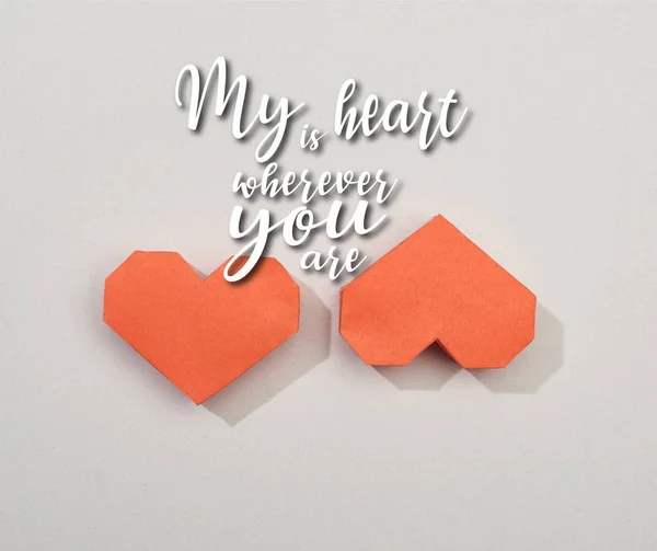 Top view of two red paper hearts on grey background with my heart is wherever you are illustration — Stock Photo