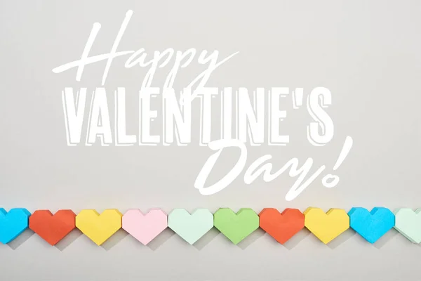 Top view of decorative papers in heart shape on grey background with happy valentines day illustration — Stock Photo