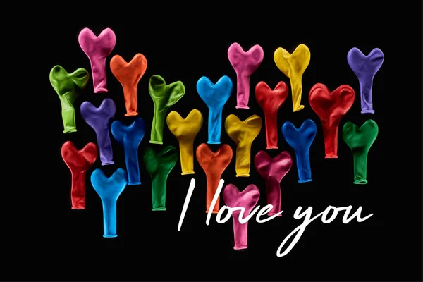 Blick von oben auf festlich bunte Luftballons auf schwarz mit i love you Schriftzug — Stockfoto