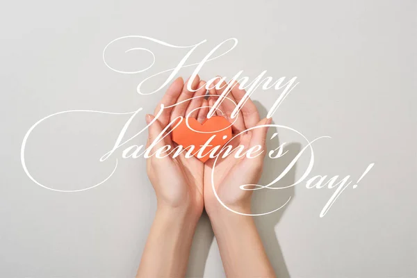 Top view of girl holding paper heart in hands on grey background with happy valentines day illustration — Stock Photo