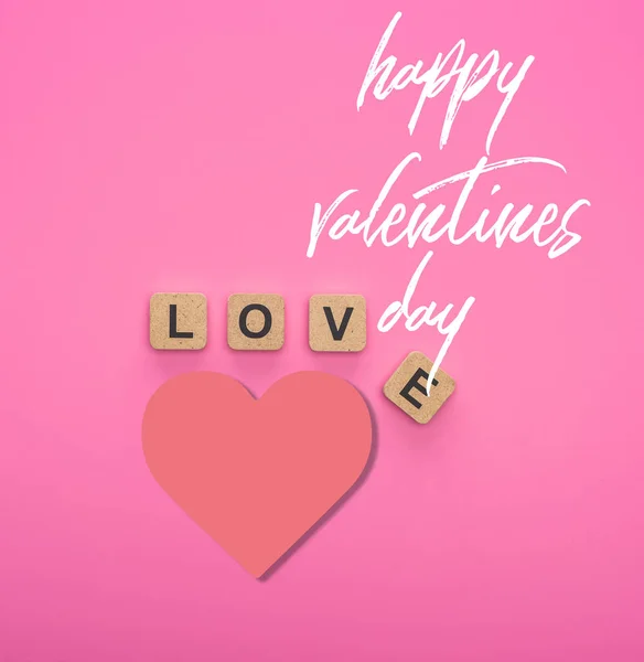 Top view of love lettering on wooden cubes on pink background with happy valentines day illustration — Stock Photo