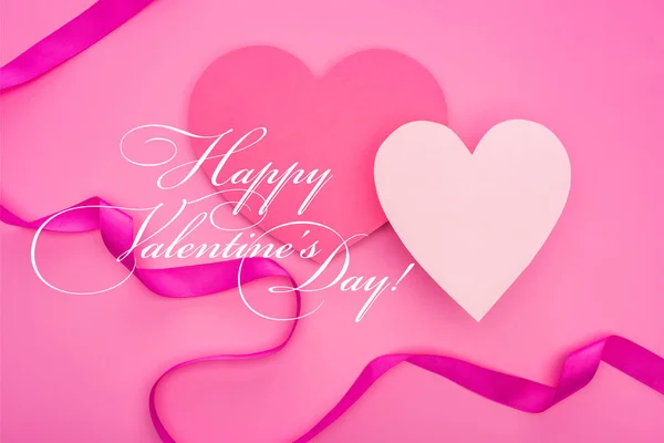 Вид зверху на порожні паперові серця зі стрічкою ізольовані на рожевому з щасливими ілюстраціями дня валентинки — стокове фото