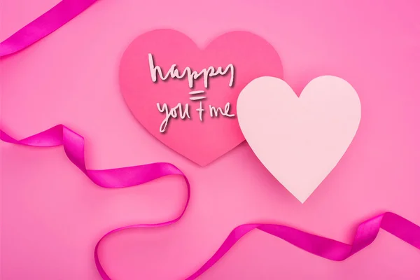Top view of empty paper hearts with ribbon isolated on pink with happy you and me lettering — Stock Photo