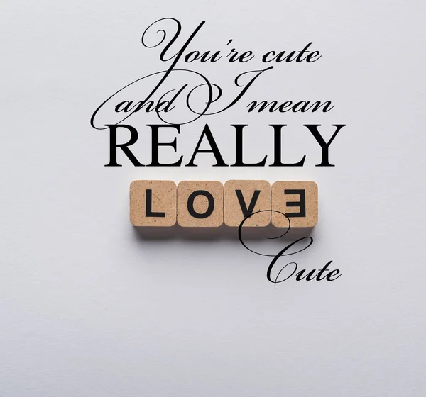 Top view of cubes with love lettering on white background with you are cute lettering — Stock Photo