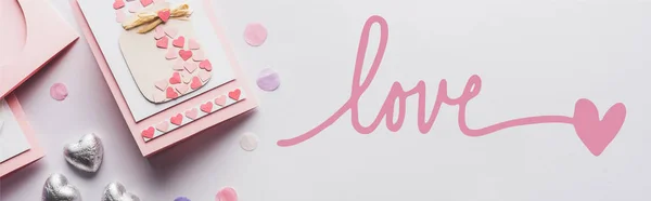 Vista superior de la decoración de San Valentín, tarjeta de felicitación, corazones, confeti sobre fondo blanco con letras de amor, plano panorámico - foto de stock