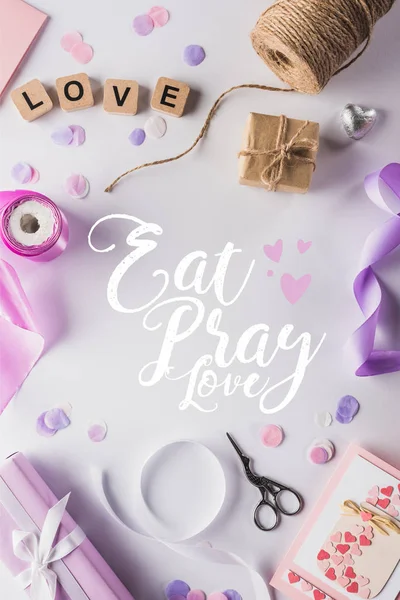 Ansicht von Valentinstagsdekoration, Geschenken, Bastelmaterial und Liebesbriefen auf Würfeln auf weißem Hintergrund mit eat, pray, love illustration — Stockfoto