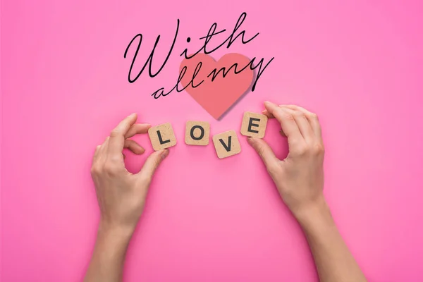 Partial view of woman holding cubes with love lettering on pink background with all my lettering — Stock Photo