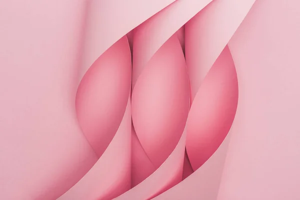 Top view of pink paper swirls on pink background — Stock Photo