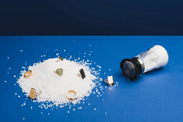 Schmuckringe mit Edelsteinen auf Salz von Salzkeller auf klassisch blauem Hintergrund — Stockfoto
