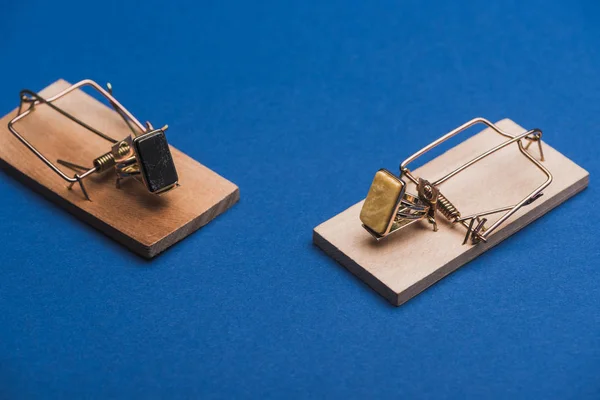 Anillos de joyería en trampas de ratón de madera sobre fondo azul - foto de stock