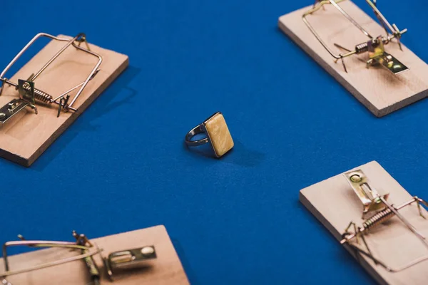 Concentration sélective de la bague à bijoux avec pièges à souris en bois sur fond bleu — Photo de stock