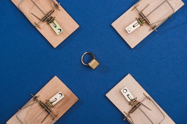 Vue du dessus de l'anneau de bijoux avec des pièges à souris sur la surface bleue — Photo de stock