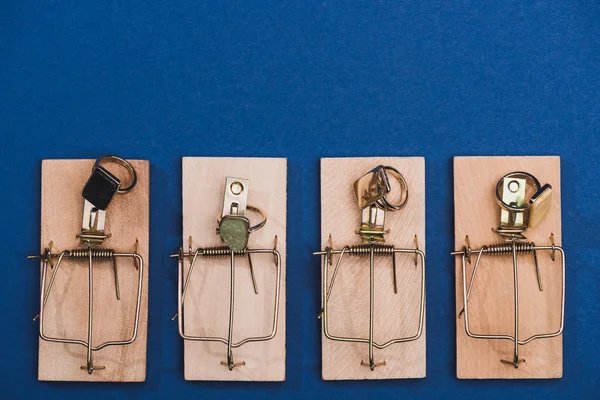 Vue du dessus des bagues à bijoux dans les pièges à souris sur fond bleu — Photo de stock