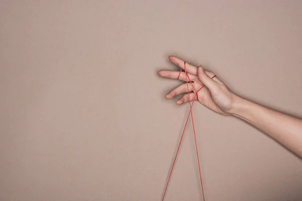 Top view of female hand with red string on beige background — Stock Photo