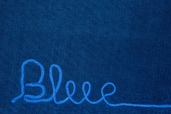 Top view of word blue from thread on blue cloth — Stock Photo