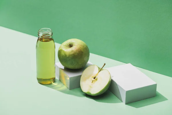 Jus frais près des pommes et des cubes blancs sur fond vert et turquoise — Photo de stock