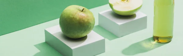 Frischer Saft in der Nähe von Äpfeln und weißen Würfeln auf grünem und türkisfarbenem Hintergrund, Panoramaaufnahme — Stockfoto