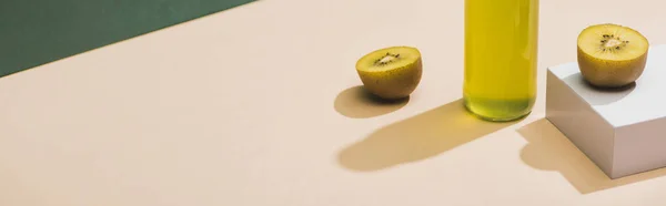 Suco fresco perto de kiwi e e cubo branco sobre fundo verde e branco, tiro panorâmico — Fotografia de Stock