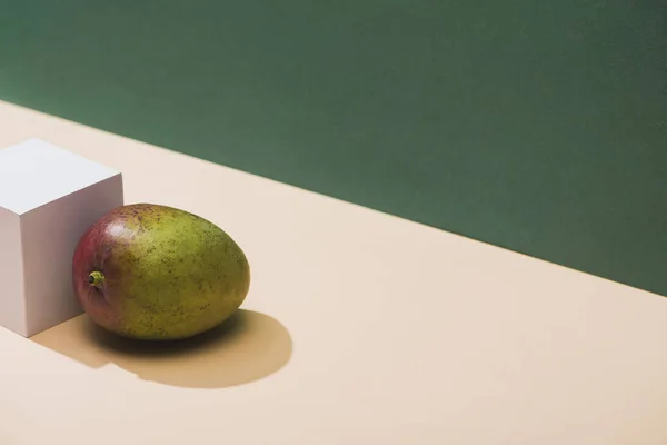 Frische Mango und White Cube auf grünem Hintergrund — Stockfoto