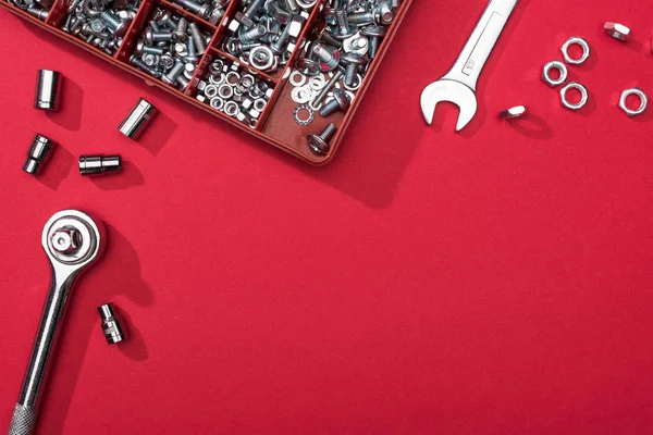 Top view of wrenches with tool box and nozzles on red background — Stock Photo