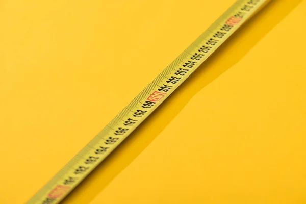 Close up view of numbers on industrial measuring tape on yellow background — Stock Photo