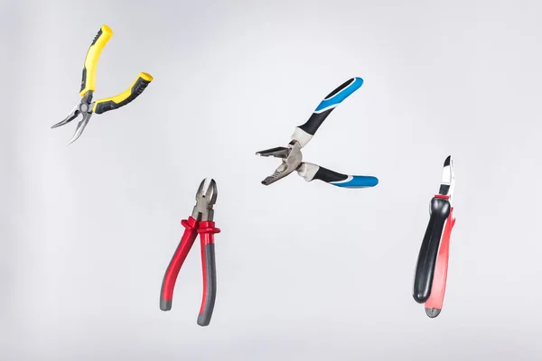 Metal pliers levitating in air isolated on grey — Stock Photo