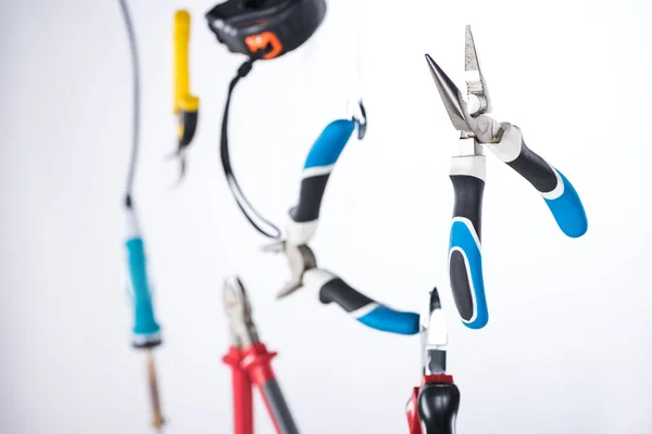 Selective focus of pliers and tools levitating in air isolated on grey — Stock Photo