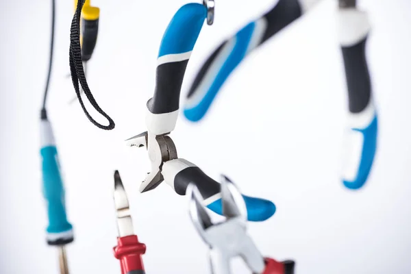 Selective focus of pliers and soldering iron levitating in air isolated on white — Stock Photo