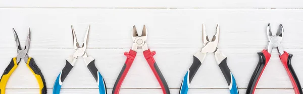 Top view of pliers on white wooden background, panoramic shot — Stock Photo