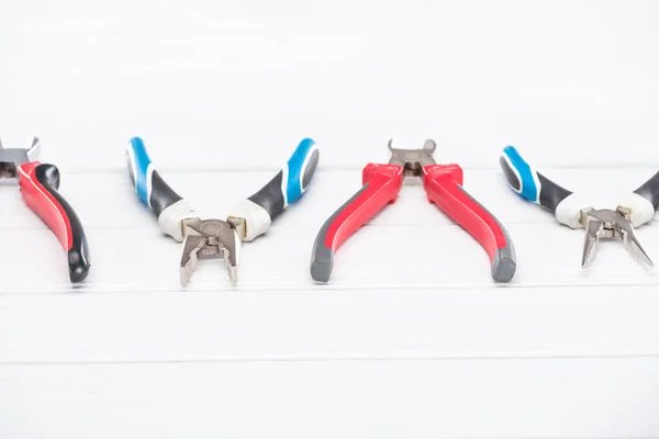 Line from pliers on white wooden surface — Stock Photo