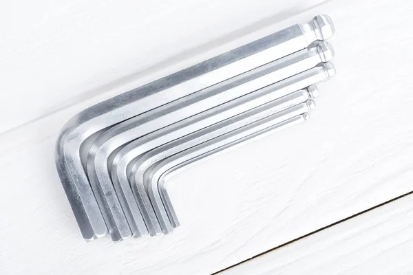 Top view of hex keys on white wooden background — Stock Photo