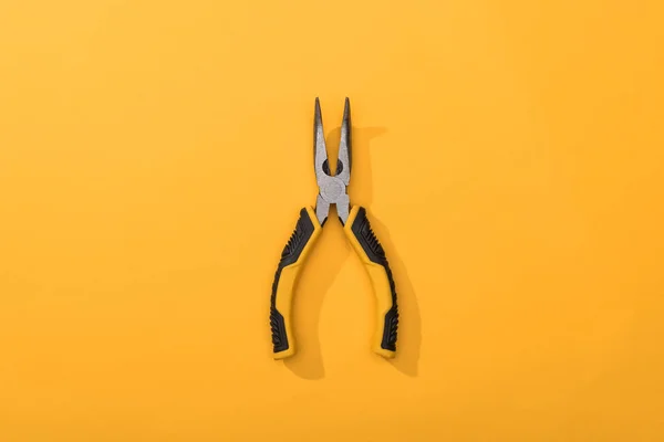 Top view of pliers on yellow background — Stock Photo