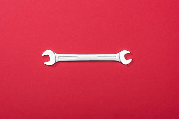 Vista dall'alto della chiave in metallo su sfondo rosso — Foto stock