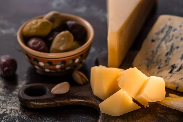 Selective focus of cheese platter with pistachios, olives — Stock Photo