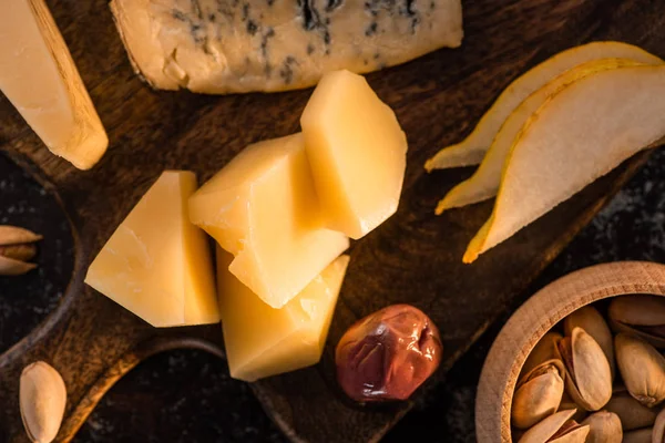 Close up view of cheese platter with sliced pear, pistachios — Stock Photo