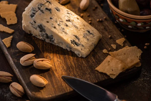 Prato de queijo com dorblu, biscoitos e pistache perto de faca — Fotografia de Stock